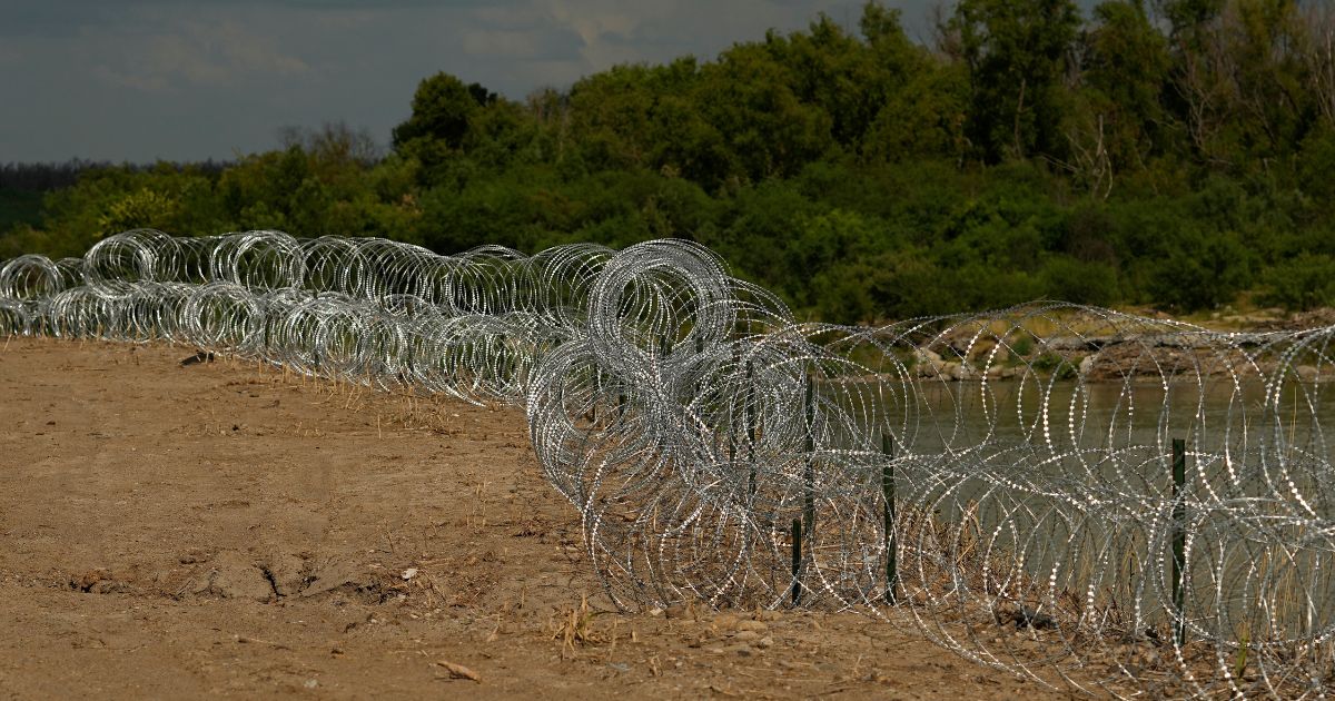 Concertina wire lines the banks of the Rio Grande on the Pecan farm of Hugo and Magali Urbina, near Eagle Pass, Texas, on July 7.