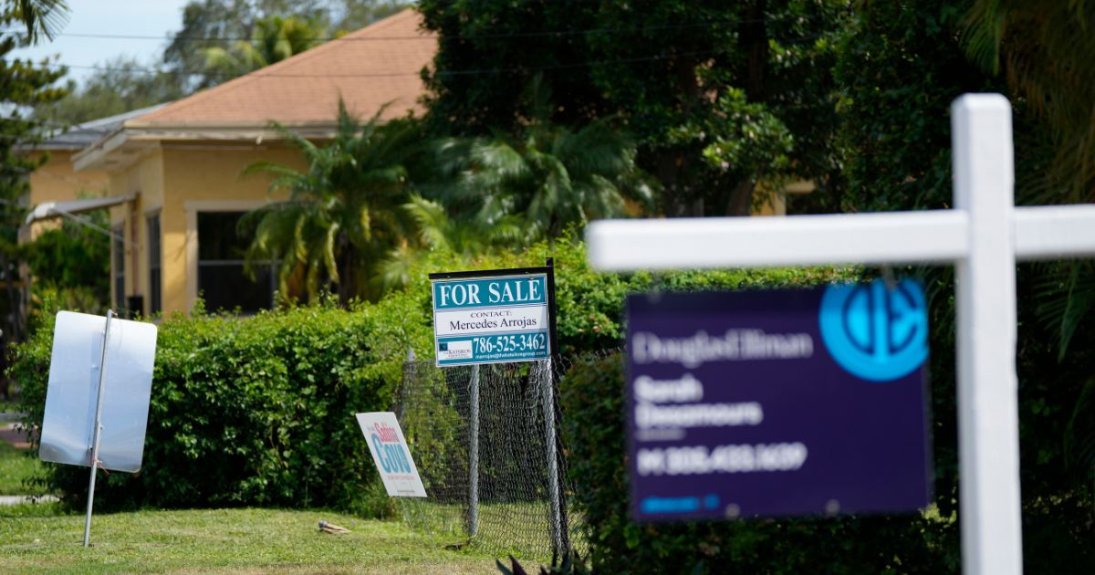 Realty signs indicating homes for sale hang in front of properties in the Coconut Grove neighborhood of Miami on Thursday.