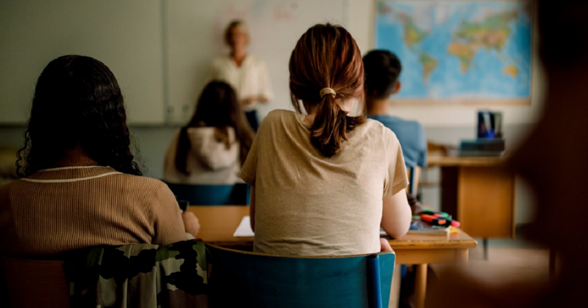 A classroom picture shows students from behind.