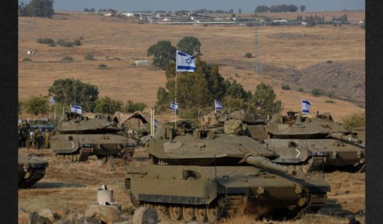 Israeli Merkava tanks are positioned in the upper Galilee in northern Israel near the border with Lebanon Wednesday. Israel appeared to be readying for a possible ground invasion of Gaza, but faces the threat of a multi-front war after also coming under rocket attack from militant groups in neighboring Lebanon and Syria.