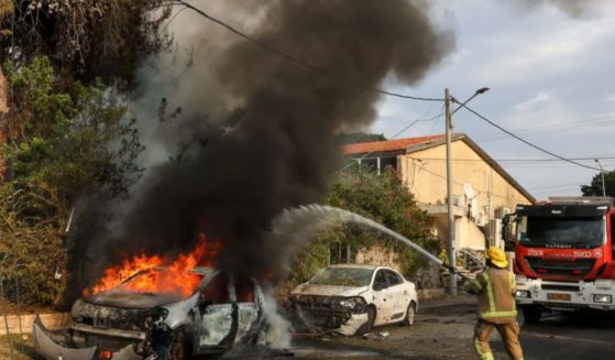 A firefighter douses a car blaze in the southern Israeli city of Ashkelon after a rocket attack from Gaza on Monday.