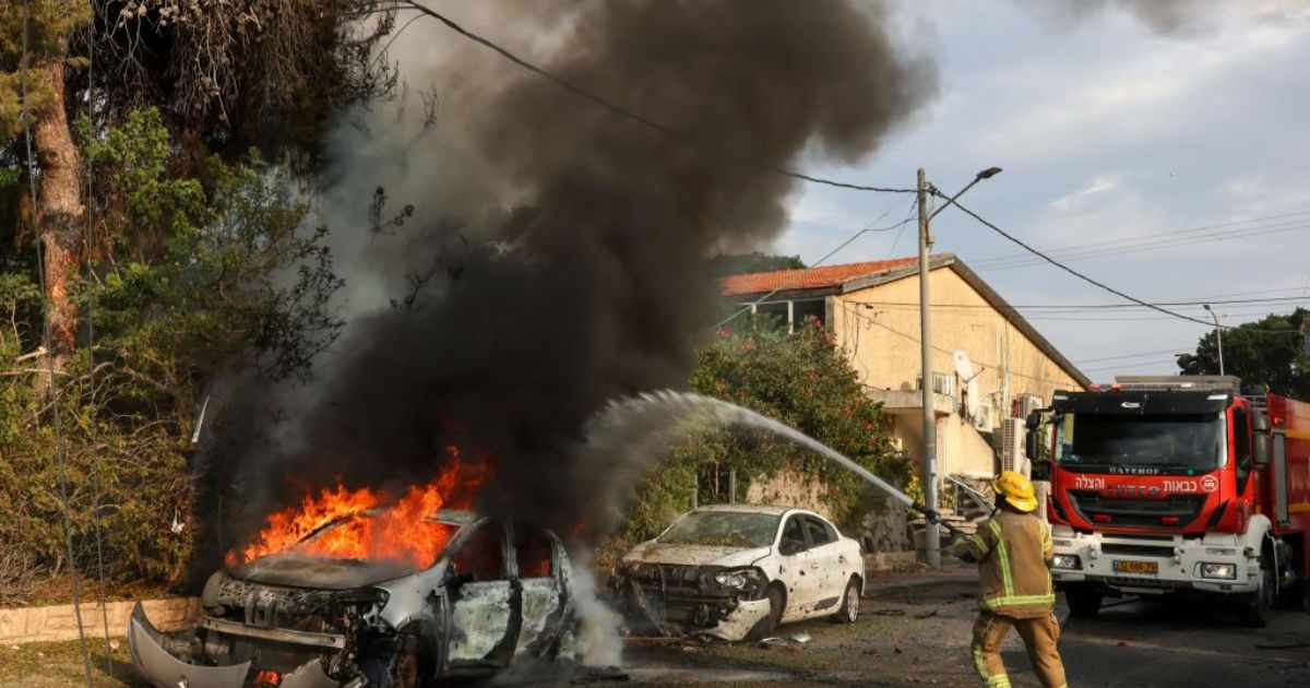A firefighter douses a car blaze in the southern Israeli city of Ashkelon after a rocket attack from Gaza on Monday.