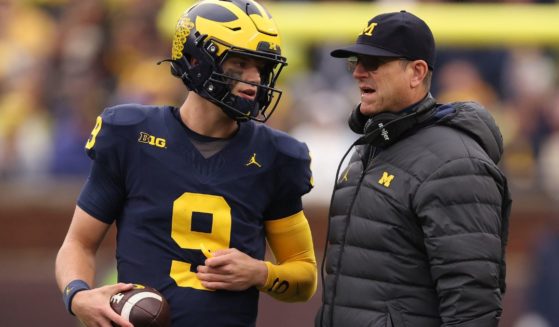 Head coach Jim Harbaugh of the Michigan Wolverines talks to J.J. McCarthy during a timeout while playing the Indiana Hoosiers at Michigan Stadium on Saturday in Ann Arbor, Michigan.