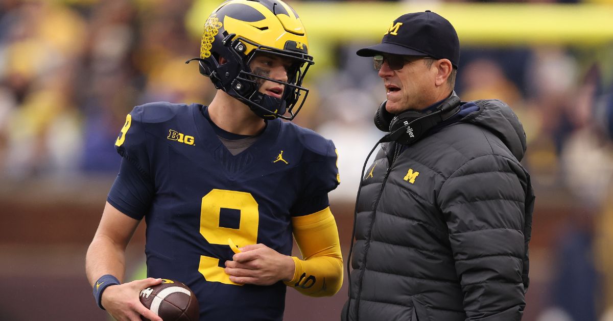 Head coach Jim Harbaugh of the Michigan Wolverines talks to J.J. McCarthy during a timeout while playing the Indiana Hoosiers at Michigan Stadium on Saturday in Ann Arbor, Michigan.