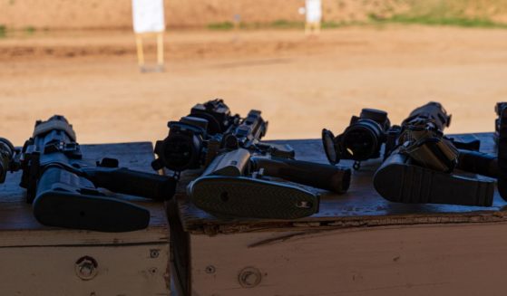 Multiple semi-automatic rifles are staged on benches in front of targets at a gun range. On Thursday, a California judge on stuck down the state's "assault weapons" ban.