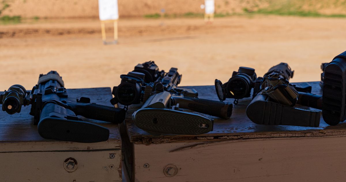 Multiple semi-automatic rifles are staged on benches in front of targets at a gun range. On Thursday, a California judge on stuck down the state's "assault weapons" ban.