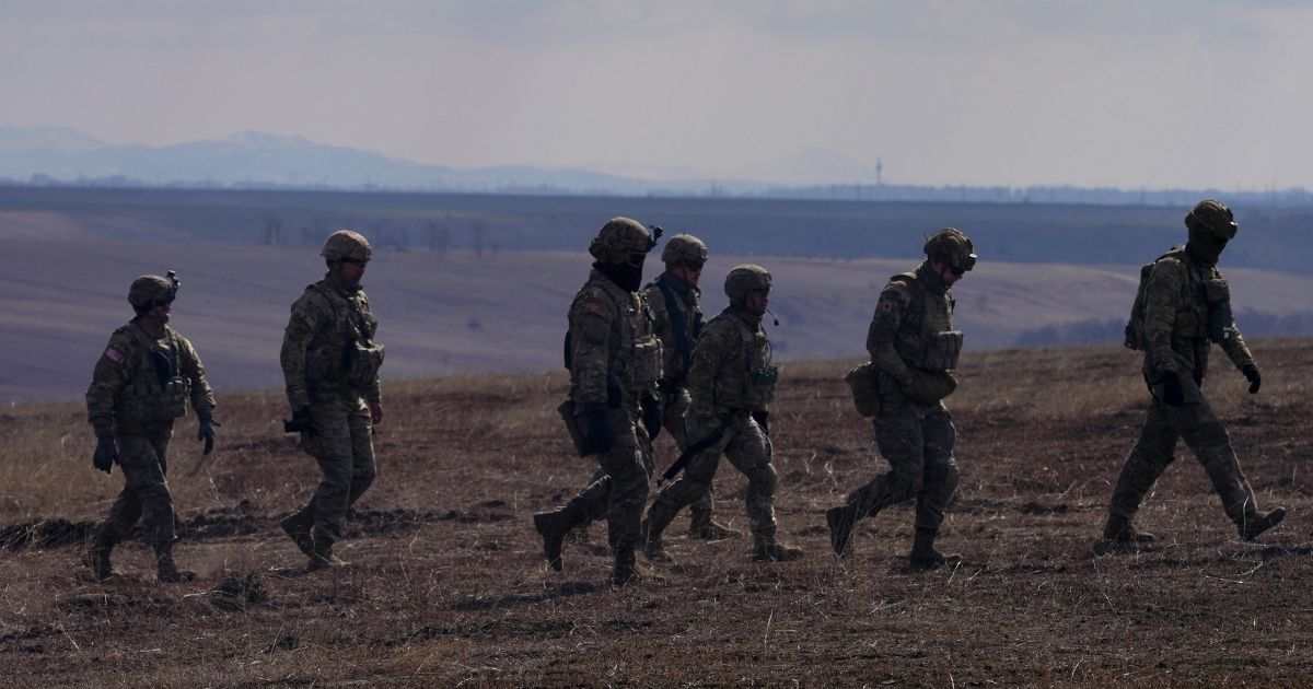 U.S. military personnel walk after a joined Romanian-U.S. military drill in Smardan, Romania, on March 10, 2022. A recent report said that the U.S. has selected around 2,000 military personnel to potentially deploy to the Middle East to support Israel. (