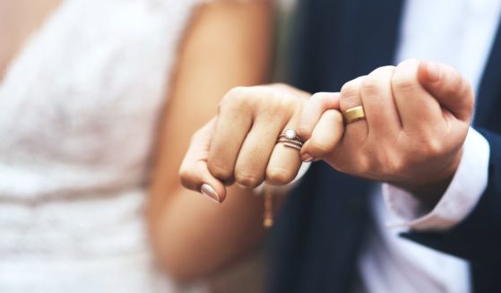 A couple on their wedding day share a photo of their wedding rings.