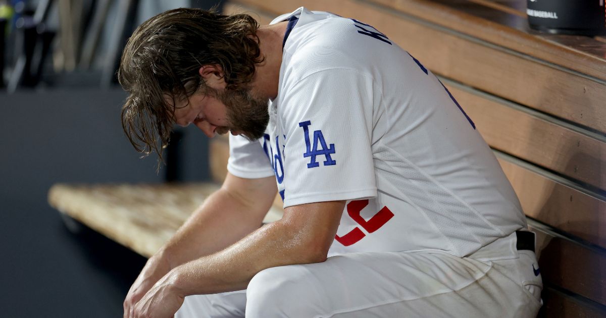 Clayton Kershaw #22 of the Los Angeles Dodgers sits in the dugout after being relieved in the first inning against the Arizona Diamondbacks during Game One of the Division Series at Dodger Stadium on Saturday in Los Angeles.