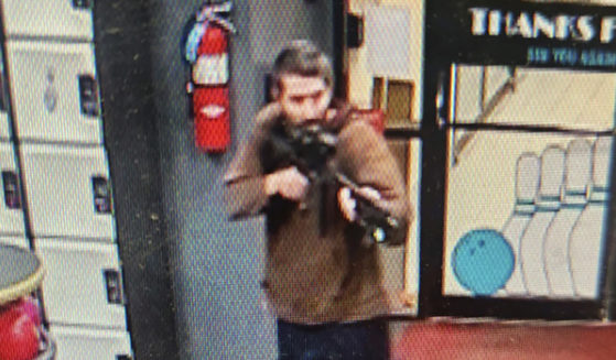 In this image taken from video released by the Androscoggin County Sheriff's Office, an unidentified shooter points a gun while entering Sparetime Recreation in Lewiston, Maine, on Wednesday.