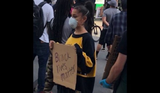 Singer Ariana Grande holds a BLM sign.
