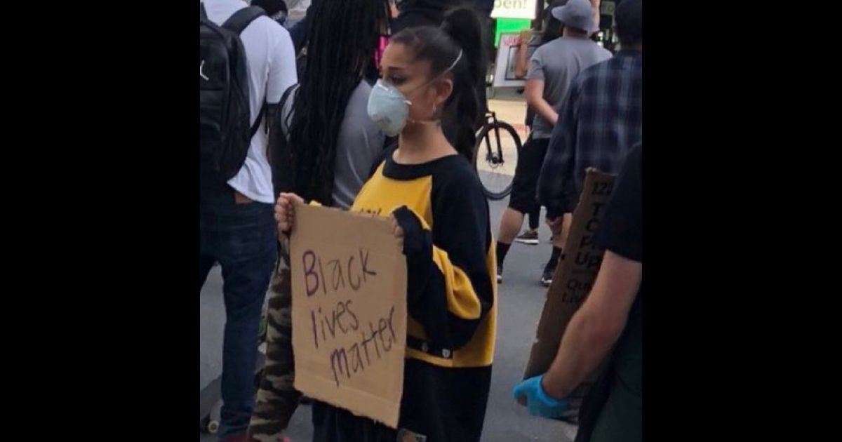 Singer Ariana Grande holds a BLM sign.