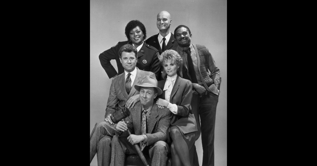 Studio portrait of the cast of the television show, 'Night Court'. L-R clockwise from center: Harry Anderson (with mallet), John Larroquette, Marsha Warfield, Richard Moll, Charles Robinson, and Markie Post.