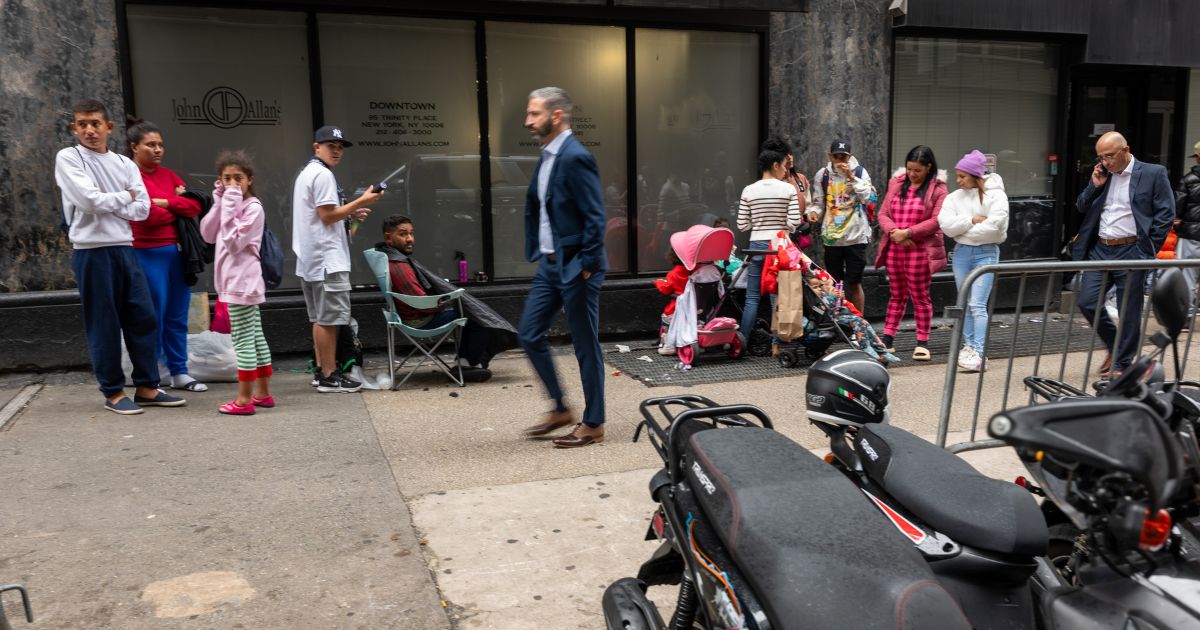 Recently arrived migrants congregate outside of the Roosevelt Hotel in midtown Manhattan on Sept. 28 in New York City.