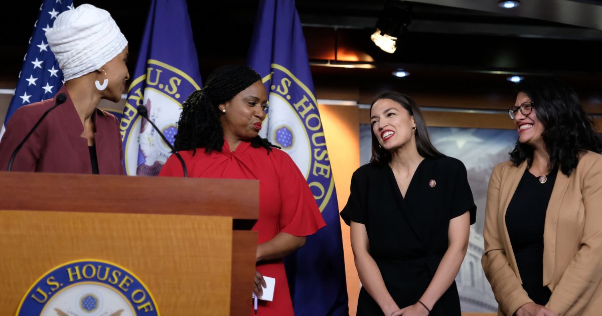 Rep. Ilhan Omar (D-MN) pauses while speaking as Reps. Ayanna Pressley (D-MA), Alexandria Ocasio-Cortez (D-NY), and Rashida Tlaib (D-MI) react during a press conference at the U.S. Capitol on July 15, 2019 in Washington, D.C.