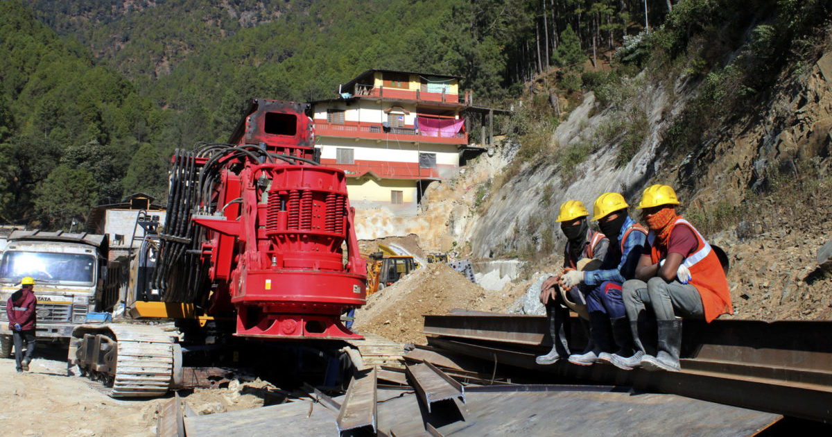 Rescuers resting at the site of an under-construction road tunnel that collapse