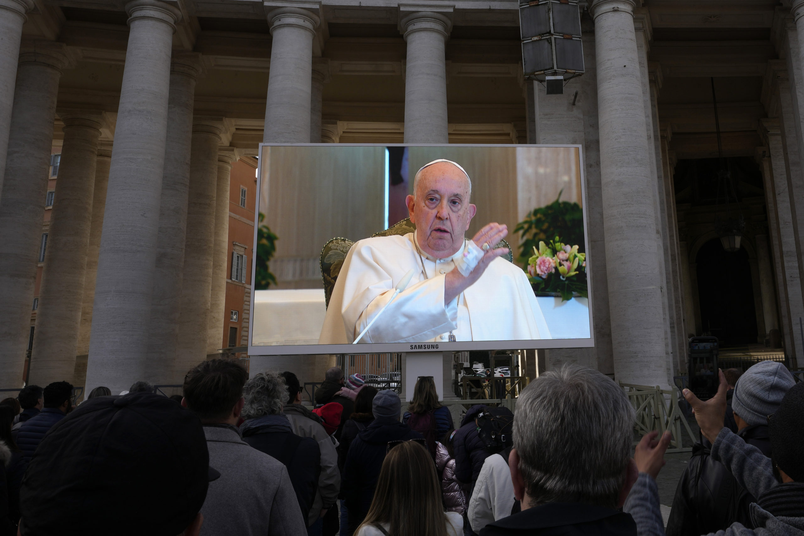 A giant screen broadcasts Pope Francis delivering his blessing during the Angelus noon prayer from the chapel of the hotel at the Vatican grounds in the Vatican City on Sunday.