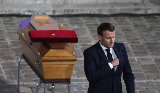 Emmanuel Macron paying respects near the coffin of a murdered French teacher