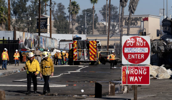 Los Angeles firefighters work to clean up the damage from a fire that severely damaged part of Interstate 10 in Los Angeles on Saturday. There has been no date given for when the section of road will reopen.