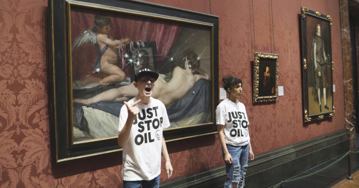In this photo provided by Just Stop Oil on Monday, climate activists stand by a painting after smashing its protective panel at the National Portrait Gallery in London.