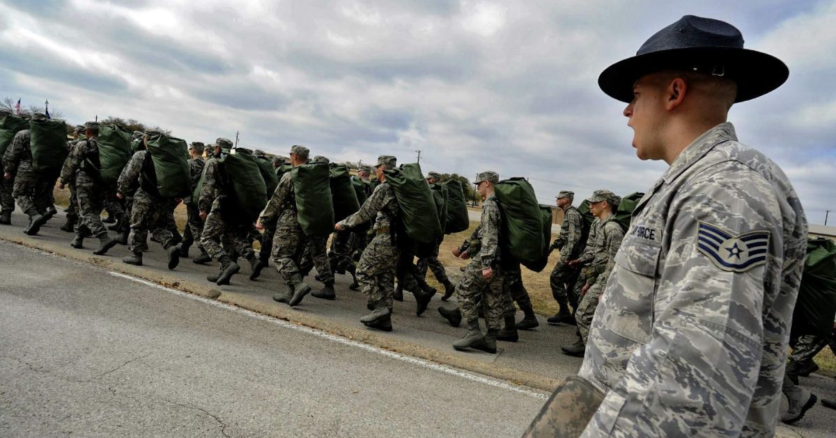 Staff Sgt. Robert George, a military training instructor at Lackland Air Force Base, Texas, marches his recruits following the issuance of uniforms and gear during basic training.