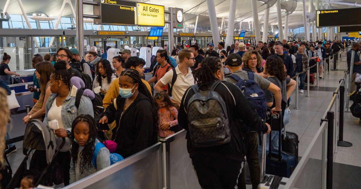 People wait in line at the security check of JFK International airport in New York City on June 30.