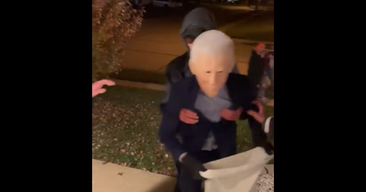 A kid in a Joe Biden costume stumbles up some stairs on Halloween.