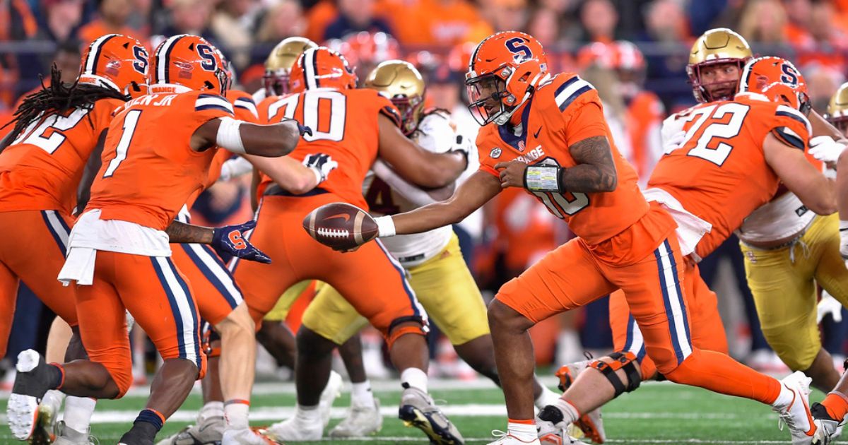 Syracuse quarterback Carlos Del Rio-Wilson, right, hands the ball to running back LeQuint Allen Jr. during the first half of the team's NCAA college football game against Boston College in Syracuse, New York, on Friday.