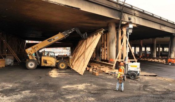This photo provided by the California Department of Transportation shows a work crew shoring up a section under Interstate 10 that was severely damaged in a fire in an industrial zone near downtown Los Angeles on Wednesday. The area under the freeway was stacked with flammable materials on lots leased by the state through a little-known program that now is under scrutiny.