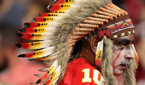 A Kansas City Chiefs fan wears a headdress and war paint during a game against the Arizona Cardinals in Glendale, Arizona, on Aug. 20, 2021. On Sunday, an image of a young Chiefs fan caused controversy due to his wearing of the headdress and black war paint.