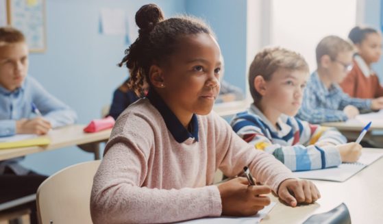 A stock photo shows children in a classroom.