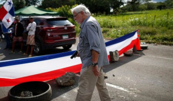 A man identified as 77-year-old Kenneth Darlington holds a gun during a confrontation with protesters blocking a road in Panama.