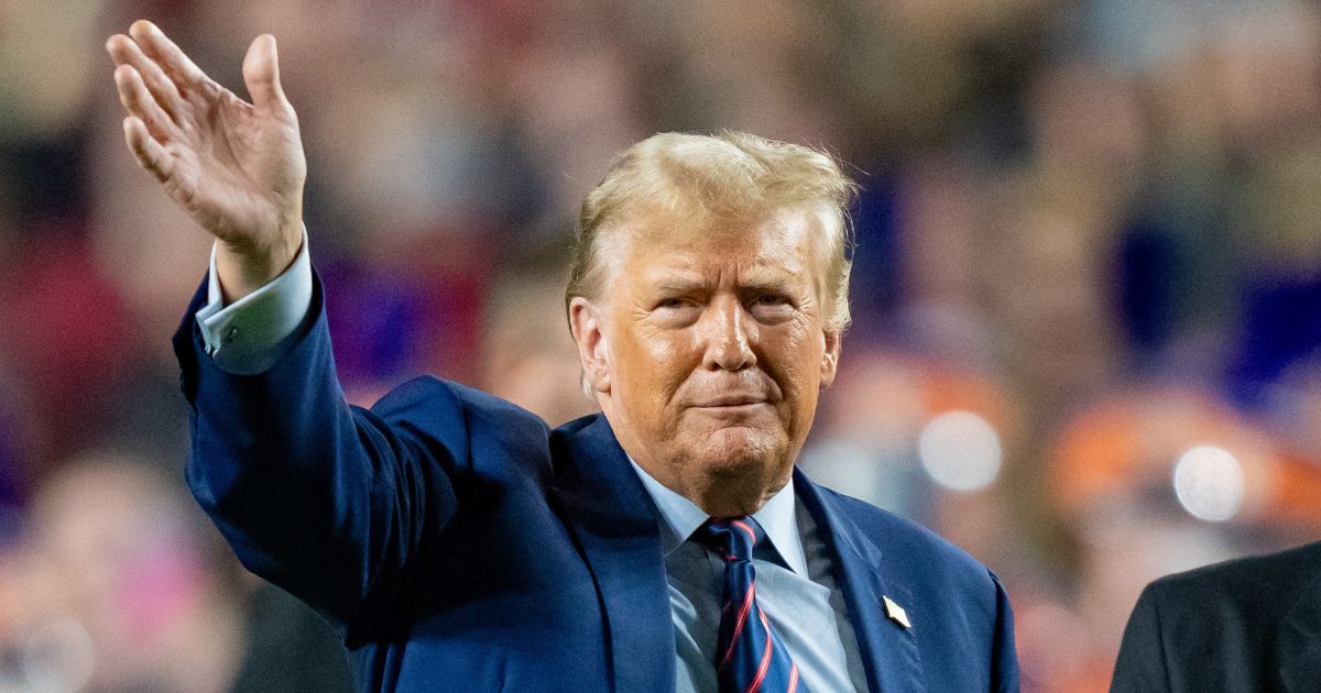 Former President Donald Trump waves to the crowd at halftime of a college football game between the South Carolina Gamecocks and the Clemson Tigers at Williams-Brice Stadium in Columbia on Saturday.