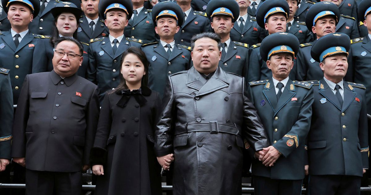 North Korean leader, Kim Jong Un, center, and his daughter, center left, pose with staff of the National Aerospace Technology Administration following the launch of a spy satellite in Pyongyang, North Korea, on Thursday.