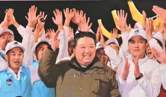 North Korean leader Kim Jong Un, center, celebrates after the reconnaissance satellite "Malligyong-1" was launched, in the Akihabara district of Tokyo on Nov. 22.