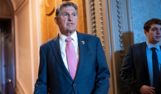 Joe Manchin speaking to a colleague just outside the Senate chamber
