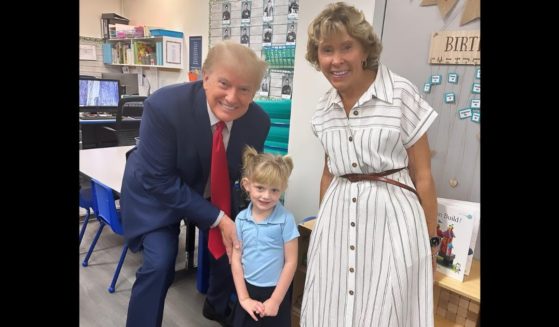 Former President Donald Trump poses with his granddaughter Caroline at her school.