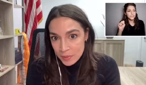 Rep. Alexandria Ocasio-Cortes is pictured in a virtual town-hall meeting on Monday. In the background is a sign language interpreter.