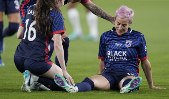 OL Reign forward Megan Rapinoe, right, stays down after an injury as teammates midfielder Rose Lavelle (16) and midfielder Jess Fishlock, center, check on her during the first half of the NWSL Championship soccer game against NJ/NY Gotham, Saturday, Nov. 11, 2023, in San Diego.
