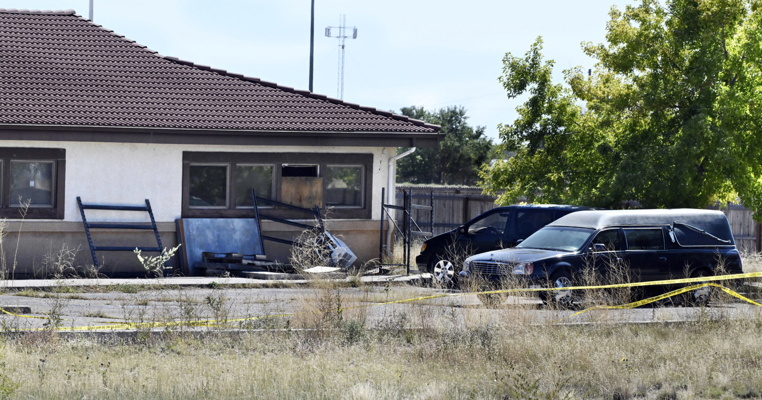 A hearse and debris can be seen at the rear of the Return to Nature Funeral Home in Penrose, Colorado, on Oct. 5.