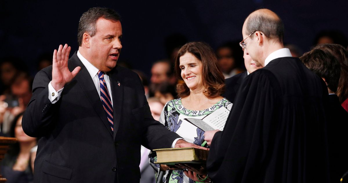 Then-New Jersey Gov. Chris Christie (L), joined by wife Mary Pat Foster (R) is sworn in by Chief Justice of the New Jersey Supreme Court Stuart Rabner for his second term on January 21, 2014 at the War Memorial in Trenton, New Jersey.