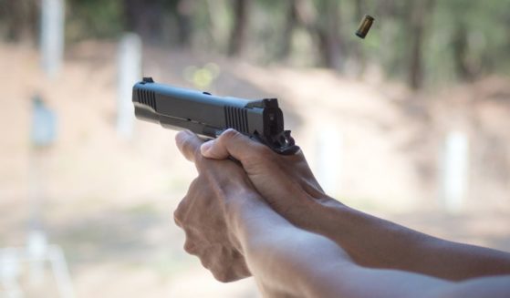 A man fires a handgun in this stock image.