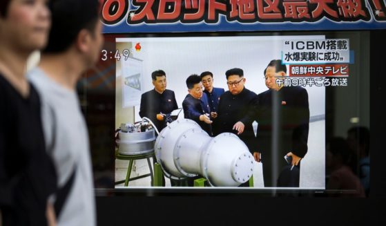 Pedestrians walk past a monitor showing an image of North Korean leader Kim Jong-Un in a news program reporting on North Korea's 6th nuclear test on September 3, 2017 in Tokyo, Japan.