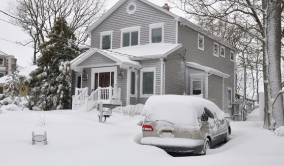 Snow covers a house in this stock image.