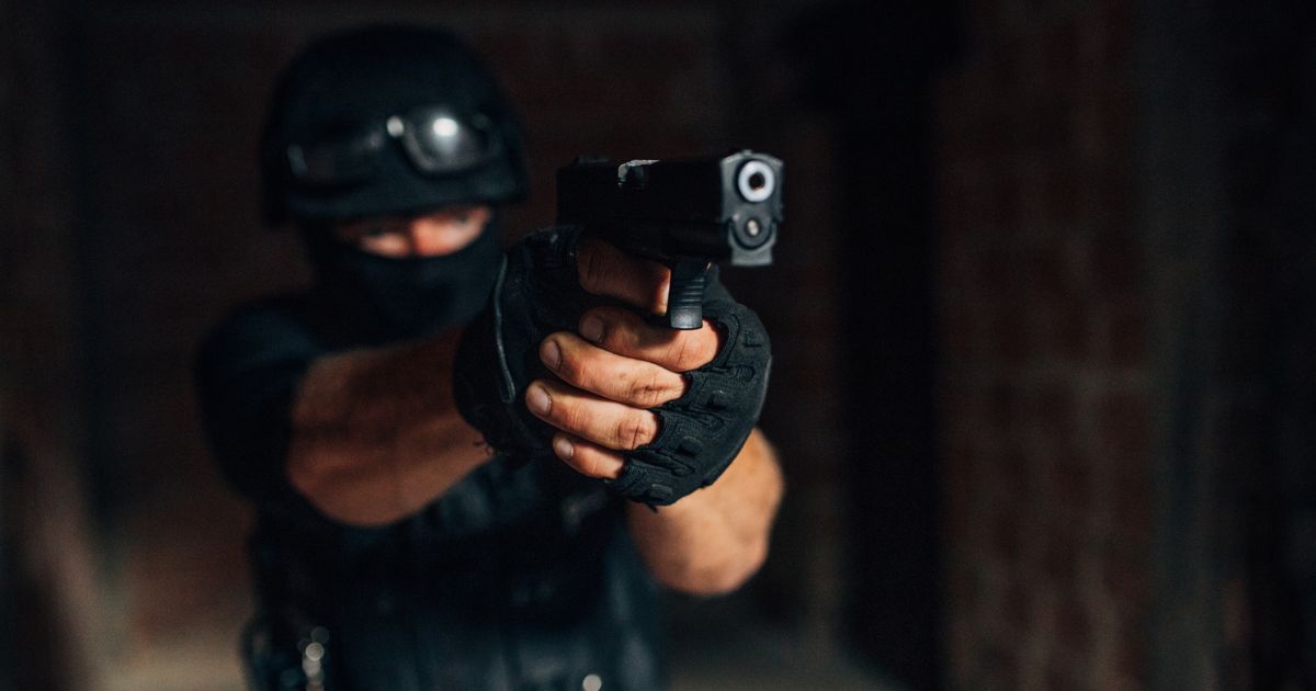 A SWAT officer points his gun in the above stock image.