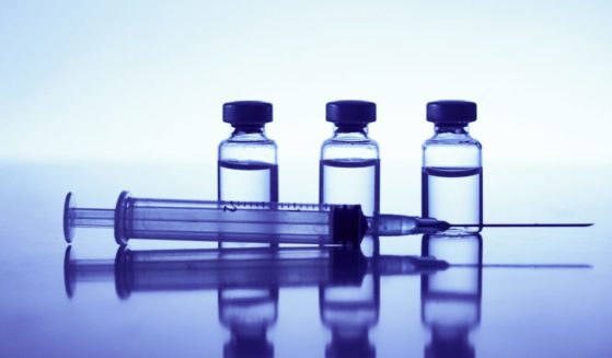 A syringe and vials are seen in this stock image.