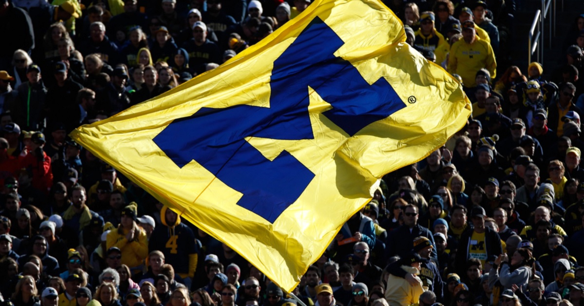 Michigan Wolverine football fans are pictured in a 2016 file photo waving a team flag.