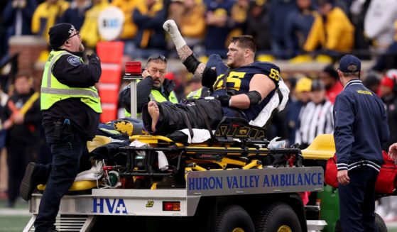 Zak Zinter of the Michigan Wolverines acknowledges the crowd as he is carted off the field after a serious injury Saturday during the third quarter in the game against Ohio State at Michigan Stadium in Ann Arbor, Michigan.