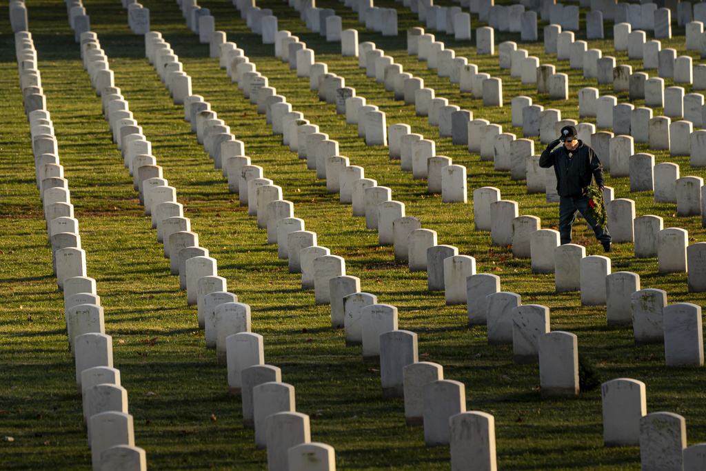 A man salutes after placing a wreath at Arlington National Cemetery during Wreaths Across America Day, Saturday, in Arlington, Virginia.