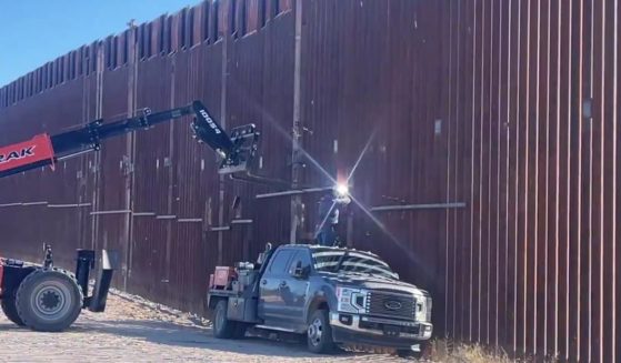 A Department of Homeland Security worker attempts to brace a section of border wall near Lukeville, Arizona.